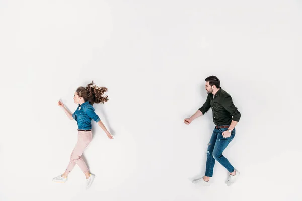 Vista superior del hombre y la mujer que fingen caminar aislados en blanco - foto de stock