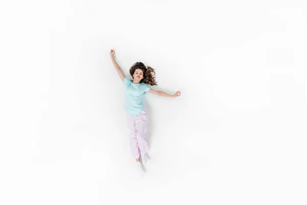 Vista dall'alto di bella giovane donna in pigiama che si estende isolata sul bianco — Foto stock