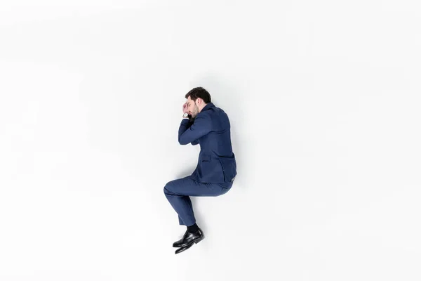 Vista superior de joven hombre de negocios durmiendo en traje aislado en blanco - foto de stock