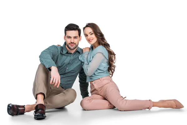 Attractive young couple sitting on floor on white — Stock Photo