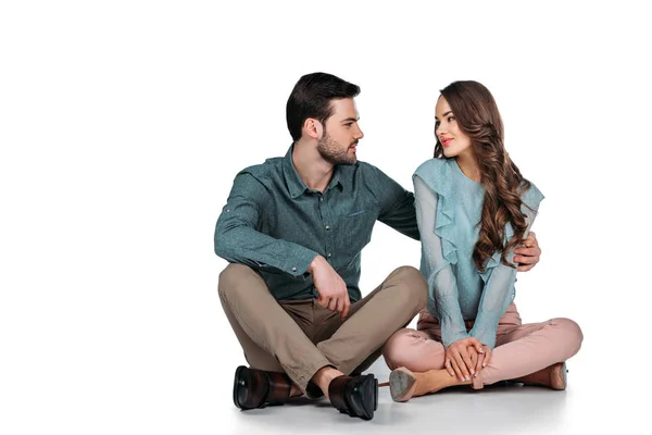 Atraente jovem casal sentado no chão no branco — Fotografia de Stock