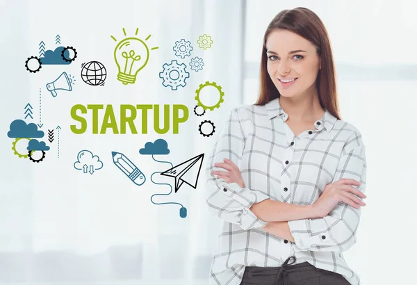 Attractive businesswoman standing with crossed arms and looking at camera, startup concept — Stock Photo