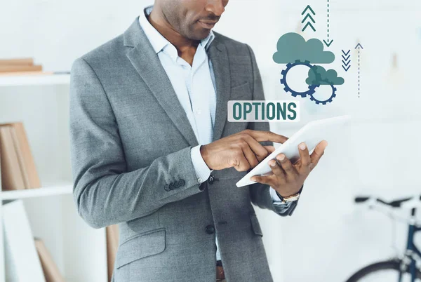 Cropped image of african american man using digital tablet and options graphic — Stock Photo