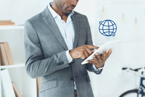 Image recadrée de l'homme afro-américain en utilisant la tablette numérique et le symbole du globe — Photo de stock