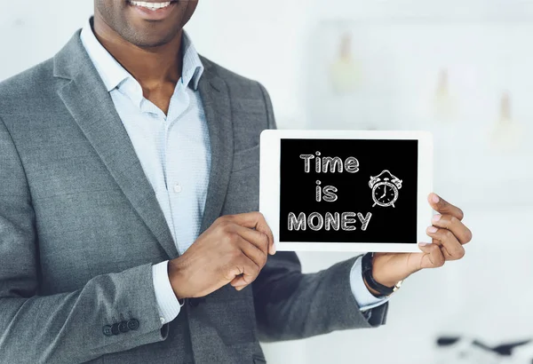 Image recadrée de sourire homme afro-américain montrant tablette numérique avec le temps d'inscription est de l'argent — Photo de stock