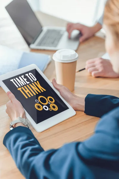 Cropped image of woman holding digital tablet with inscription time to think and cogwheels on screen — Stock Photo