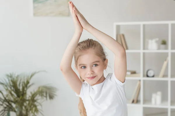 Adorable niñito practicando yoga y haciendo gesto namaste - foto de stock