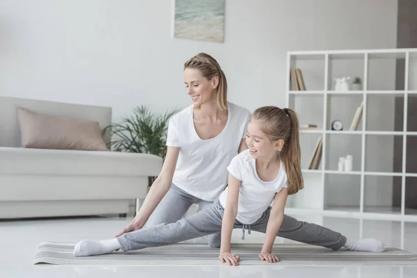 Mother helping her daughter to do twine at home — Stock Photo