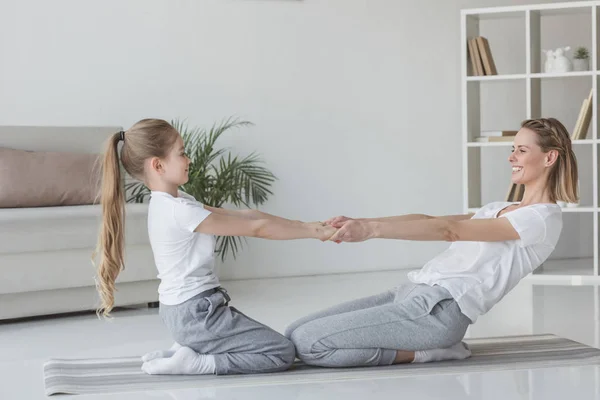 Glückliche Mutter und Tochter stehen auf Knien und praktizieren Akro-Yoga — Stockfoto