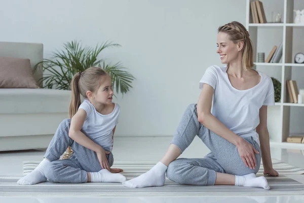 Mother and daughter practicing yoga together in Marichi's pose — Stock Photo