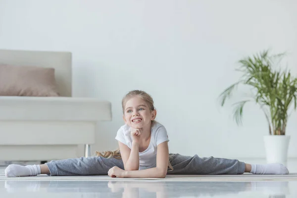 Прелестный маленький ребенок делает шпагат дома — Stock Photo