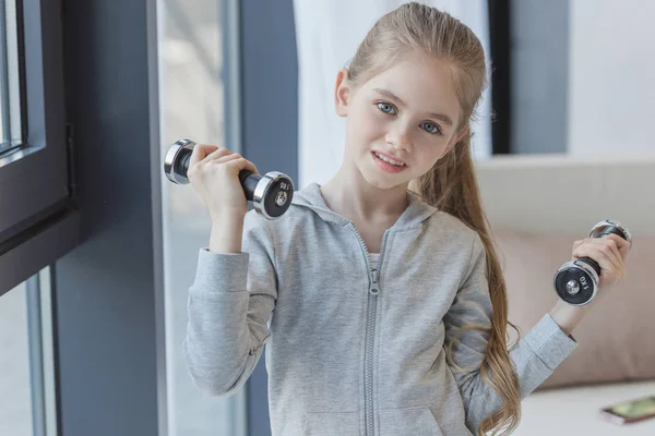 Adorable little child working out with dumbbells — Stock Photo