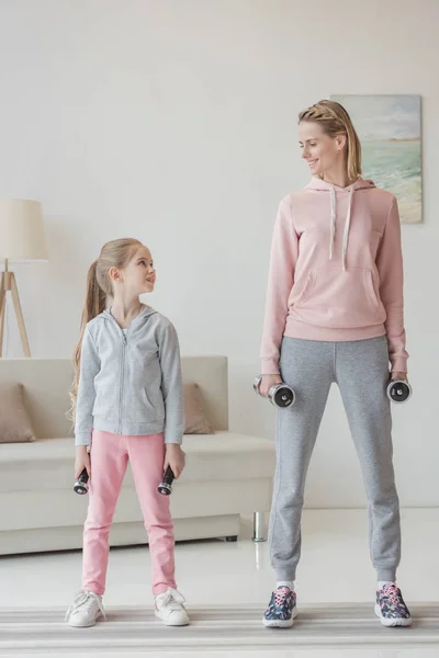 Mère et fille debout avec haltères à la maison — Photo de stock