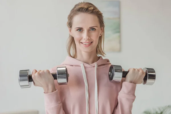 Schöne erwachsene Frau, die zu Hause mit Hanteln trainiert — Stockfoto