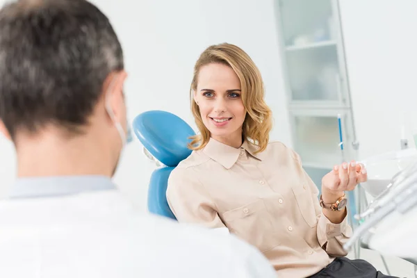 Mujer consultando con médico en clínica dental moderna — Stock Photo