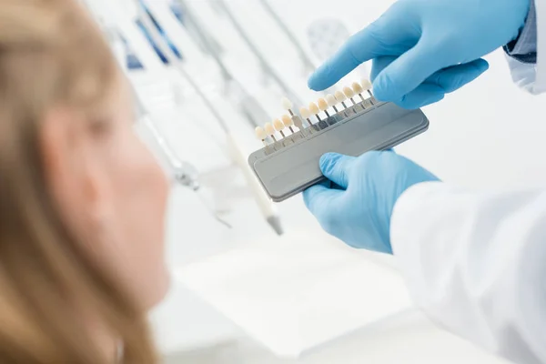 Médico y paciente eligiendo implantes dentales en clínica dental moderna - foto de stock