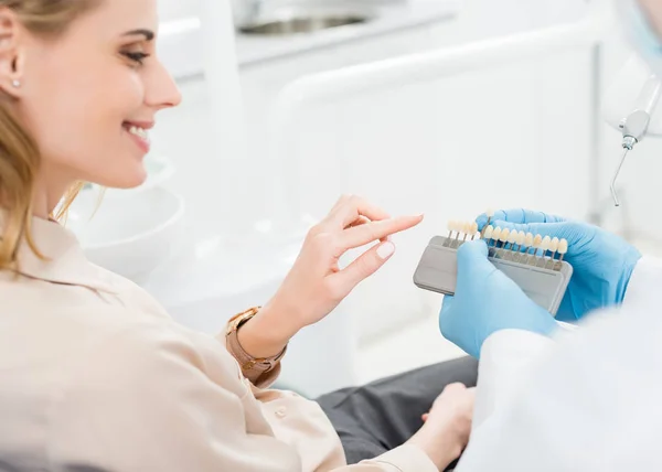 Arzt zeigt Patientin in moderner Zahnklinik Zahnimplantate — Stockfoto