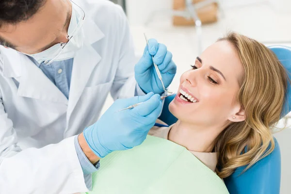 El médico trata a los dientes de los pacientes en la clínica dental moderna - foto de stock