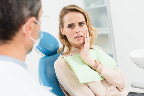 Patiente préoccupée par les maux de dents dans une clinique dentaire moderne — Photo de stock