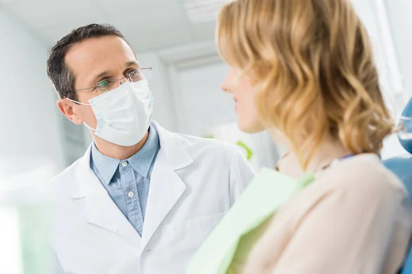 Femme consultation avec un médecin dans une clinique dentaire moderne — Photo de stock