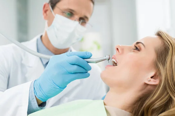 Paciente feminina em procedimento odontológico usando broca dentária na clínica odontológica moderna — Fotografia de Stock