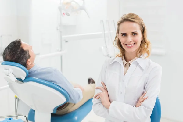 Женщина-врач со сложенными руками в современной стоматологической клинике — стоковое фото
