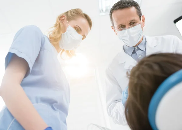 Équipe de médecins aidant le patient dans une clinique dentaire moderne — Photo de stock