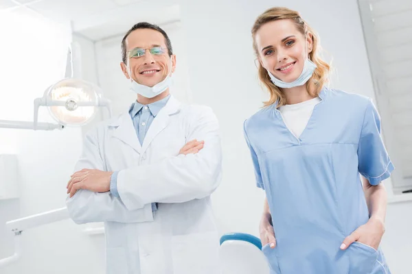 Médicos confiados sonrientes en clínica dental moderna - foto de stock