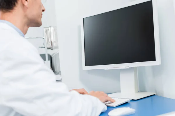Médico trabajando por computadora en clínica moderna - foto de stock