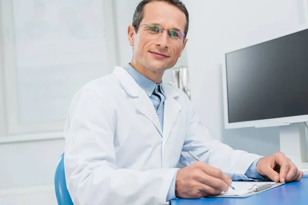 Arzt füllt Checkliste per Computer in moderner Klinik aus — Stockfoto