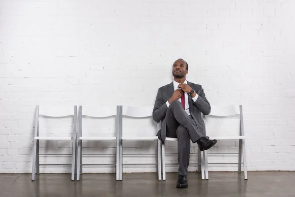 Hombre de negocios afroamericano en traje esperando entrevista de trabajo - foto de stock