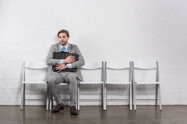 Asustado caucásico hombre de negocios con maleta a la espera de entrevista de trabajo - foto de stock