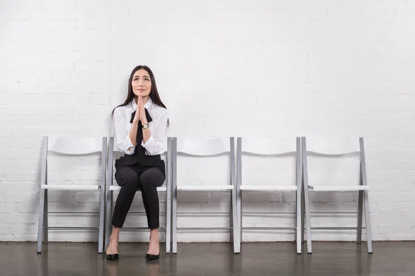 Asiatische Geschäftsfrau beten, während warten auf Vorstellungsgespräch — Stockfoto