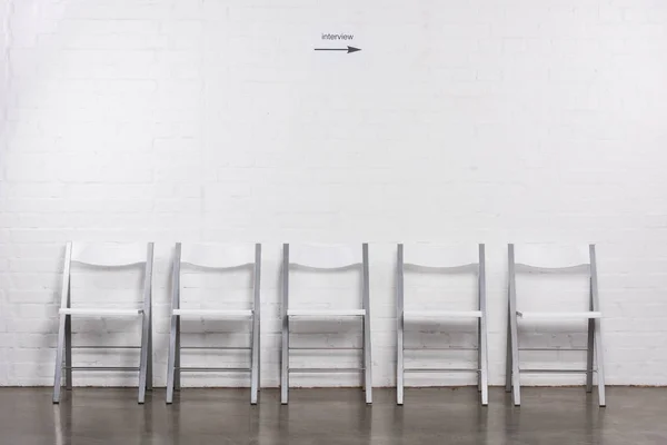 Close up view of arranged empty chairs in hall for visitors of job interview — Stock Photo