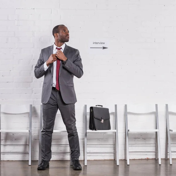 African american businessman tying bow tie waiting for job interview — Stock Photo