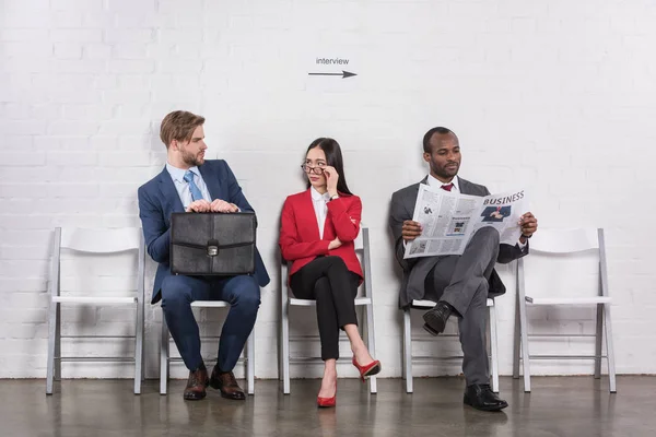 Uomini d'affari multietnici seduti sulle sedie in attesa di un colloquio di lavoro — Foto stock