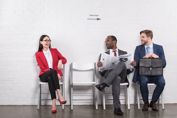 Lächelnde multiethnische Geschäftsleute warten auf Vorstellungsgespräch — Stockfoto