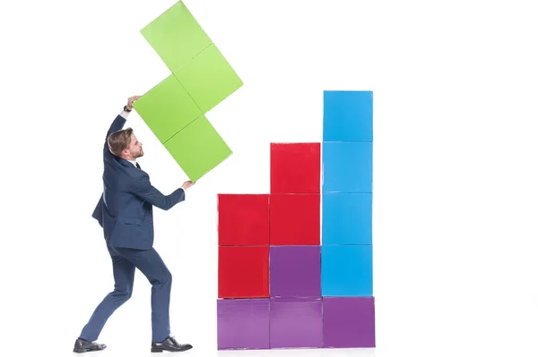 Hombre de negocios recogiendo bloques de colores aislados en blanco - foto de stock