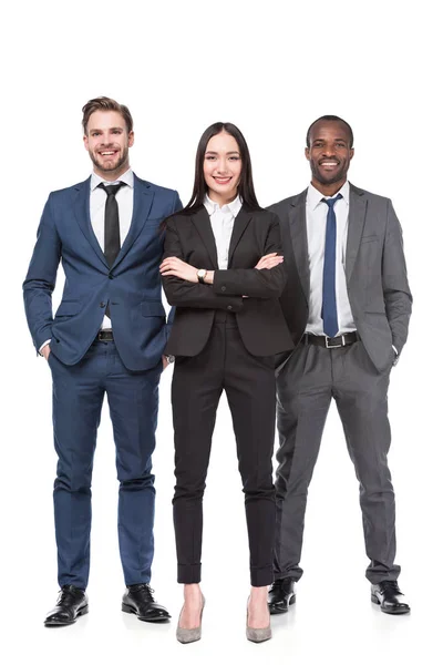 Sonrientes jóvenes empresarios multiculturales en trajes aislados en blanco - foto de stock