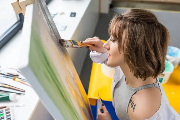 Giovane ragazza ispirato pittura da cavalletto in studio di luce — Foto stock