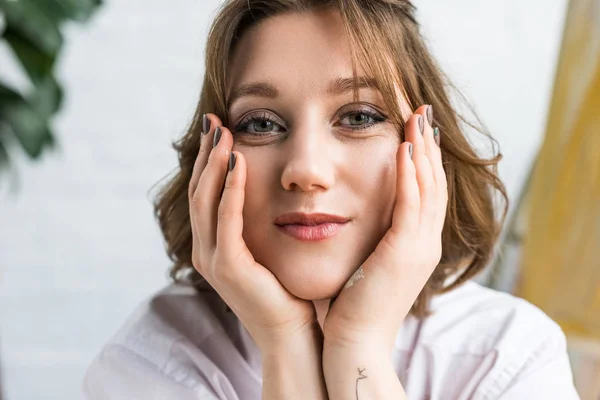 Young artistic girl looking at camera in light studio — Stock Photo