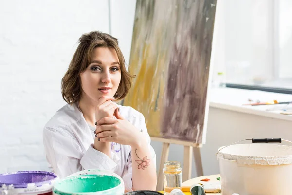 Chica creativa joven con la mano en la barbilla en el estudio de luz - foto de stock