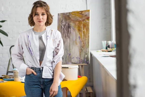 Jeune fille artistique debout dans le studio de lumière — Photo de stock