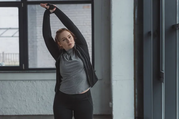 Fettleibiges Mädchen streckt Arme im Fitnessstudio aus — Stockfoto
