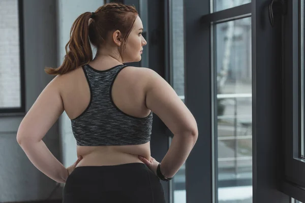 Chica obesa vistiendo top deportivo en gimnasio - foto de stock