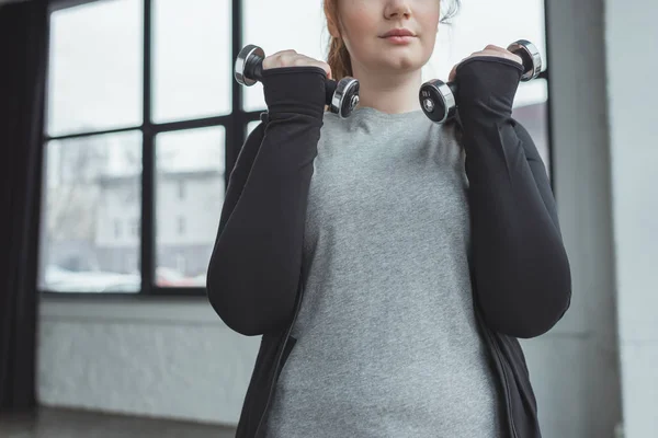 Addestramento femminile in sovrappeso con manubri in palestra — Foto stock