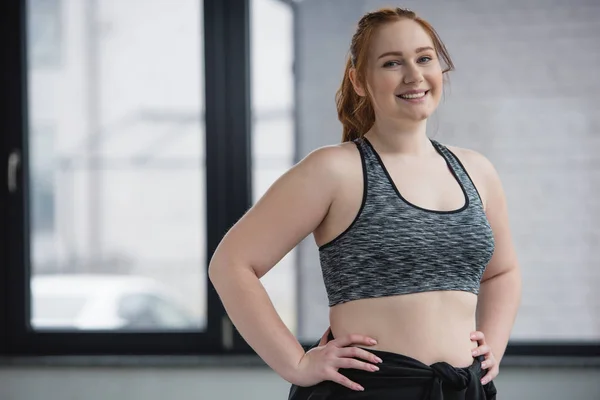 Chica curvilínea con top deportivo en el gimnasio - foto de stock