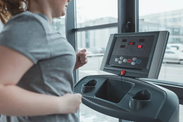 Fille obèse courir sur tapis roulant dans la salle de gym — Photo de stock