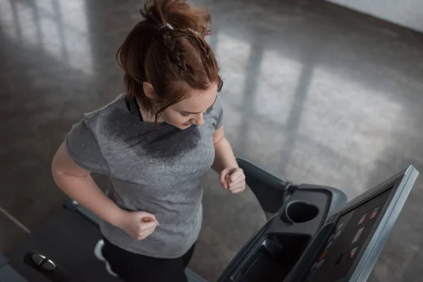 Chica con sobrepeso corriendo en la cinta en el gimnasio - foto de stock