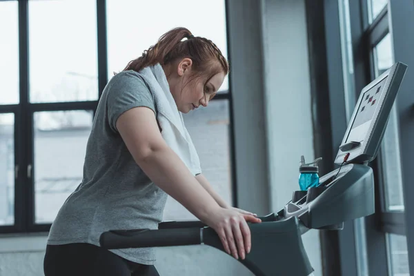 Fettleibiges Mädchen ruht sich im Fitnessstudio auf Laufband aus — Stockfoto